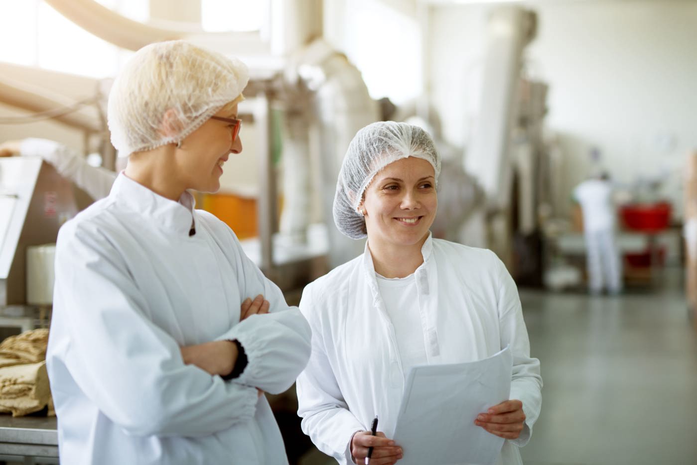 Zwei Qualitätsmanagerinnen führen Kontrollen in einem Produktionsbetrieb durch.