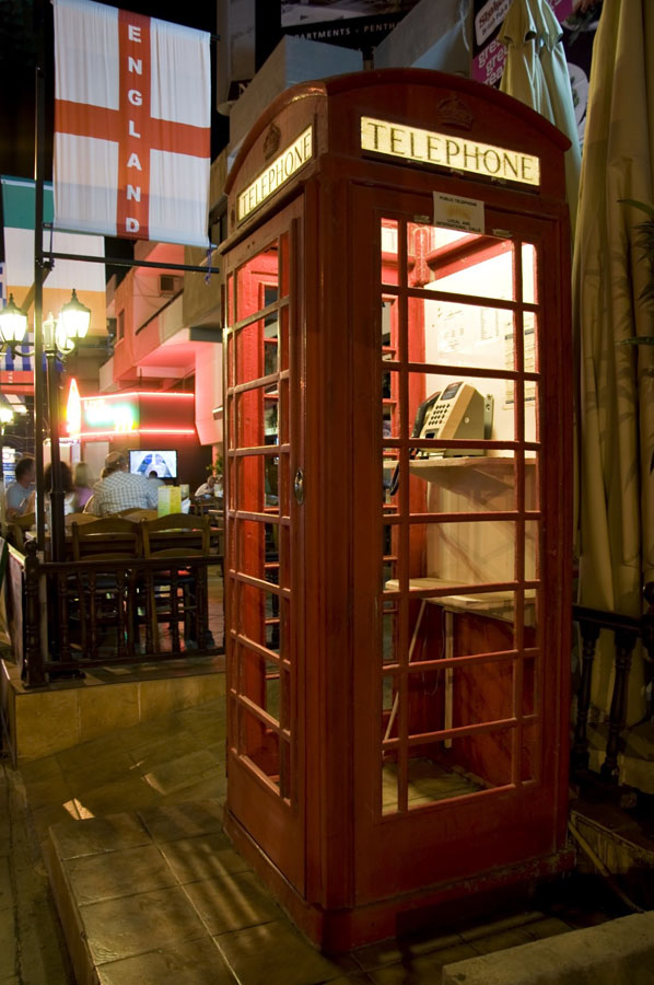 Britische Telefonkabine mit Pub im Hintergrund