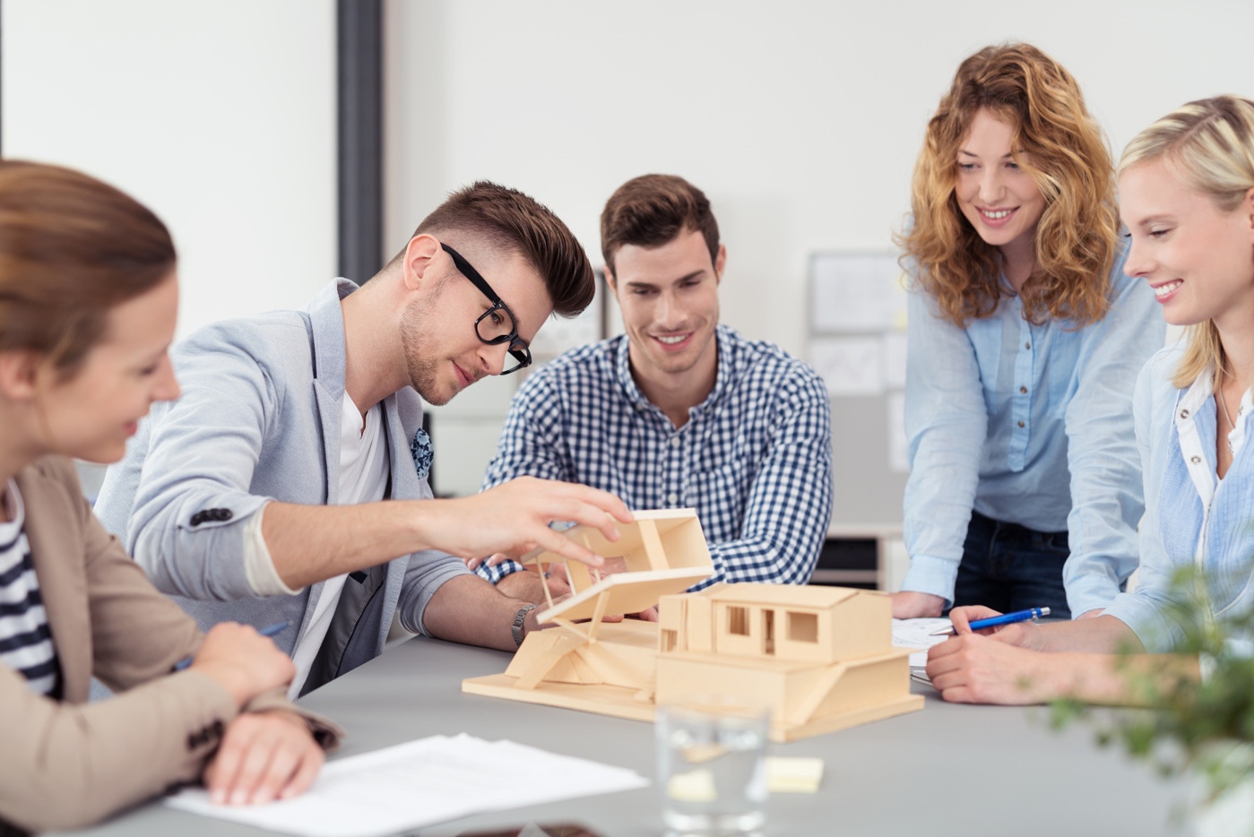 Architektur Bachelor Studenten und Studentinnen einer Fachhochschule erstellen ein Haus-Modell aus Holz für eine Projektarbeit.