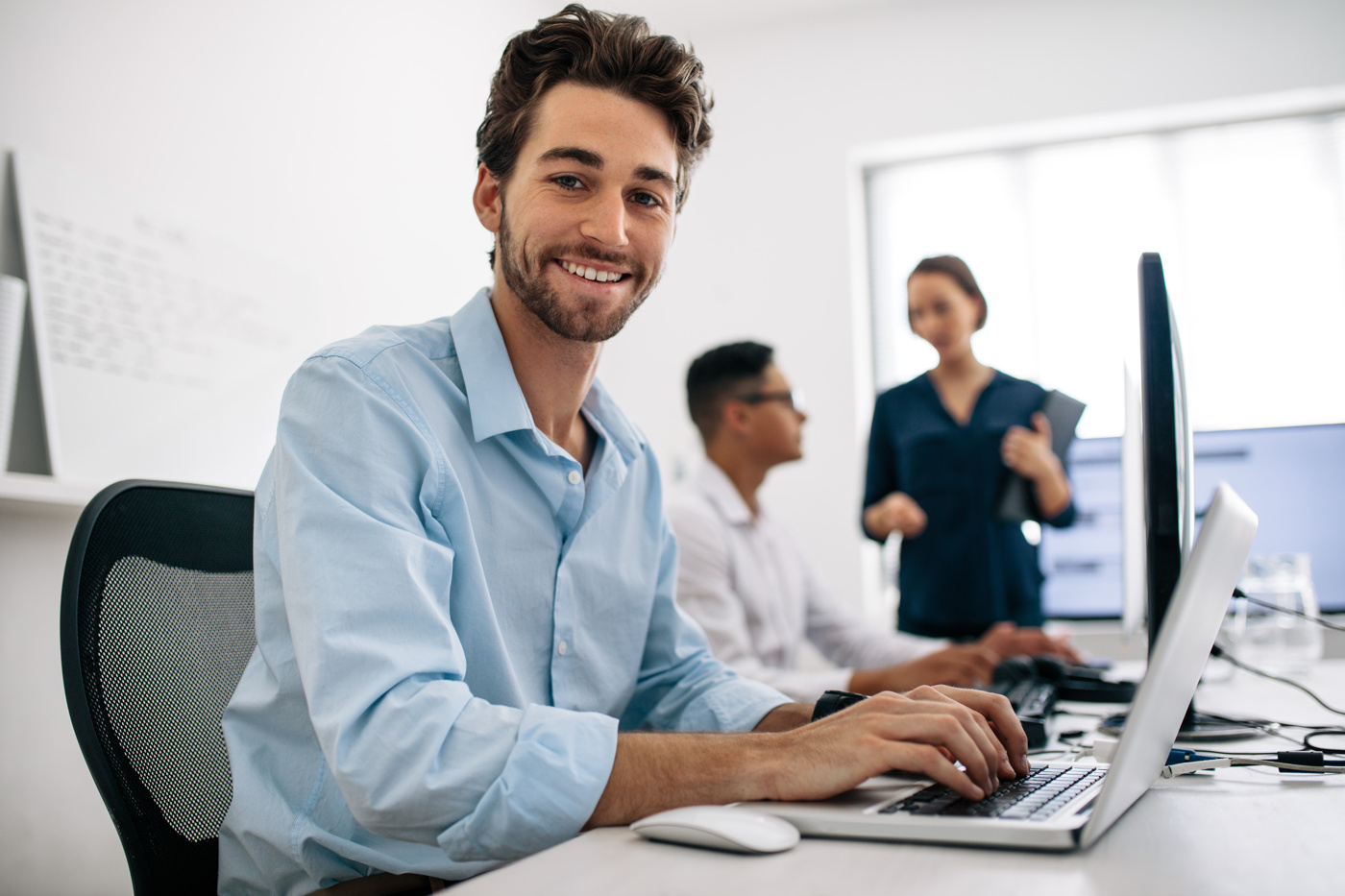 Uomo che lavora al suo computer portatile e risolve problemi per la sua laurea in informatica presso un'università di scienze applicate.