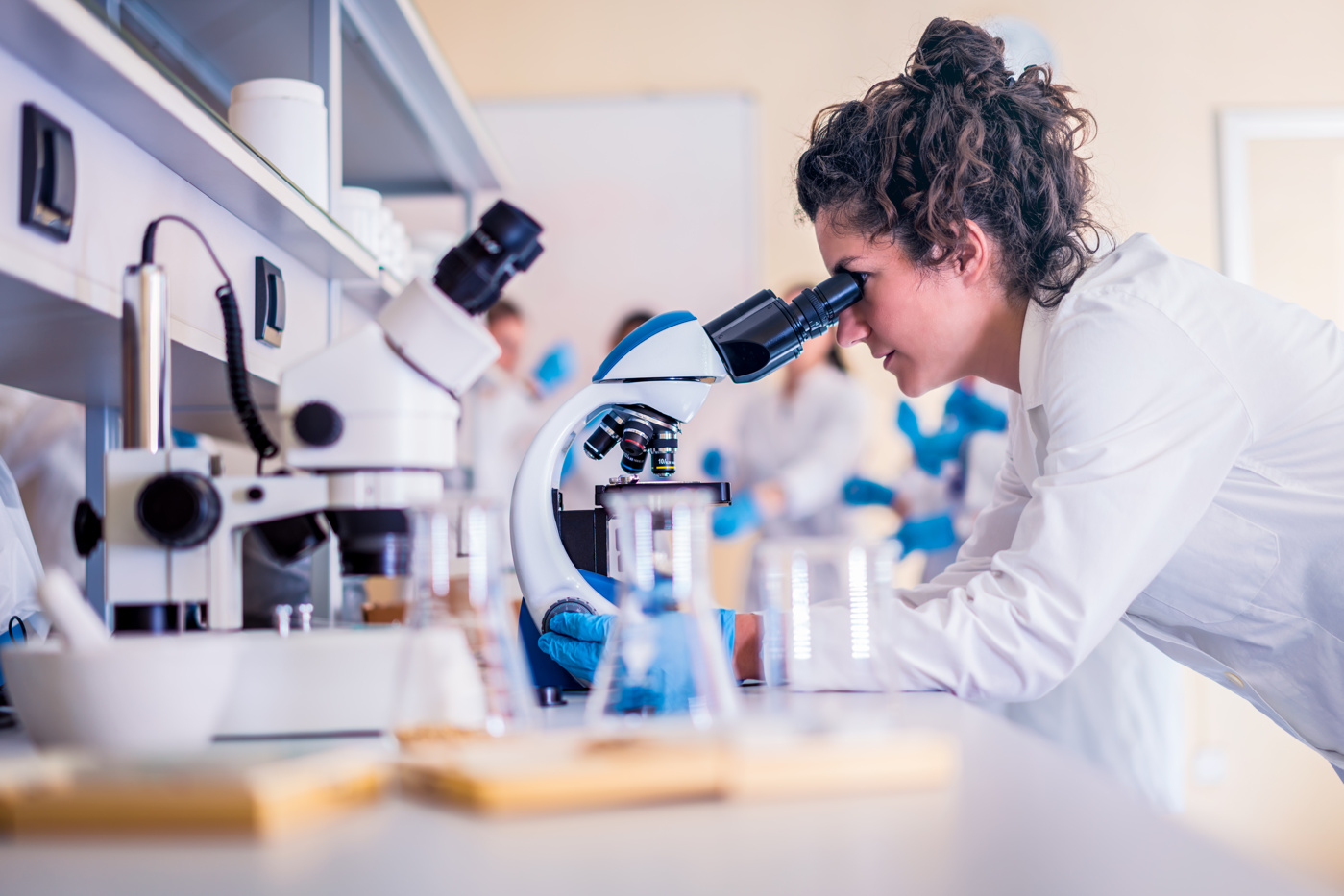 A biomedical analyst HF analyzes a tissue sample under the microscope.