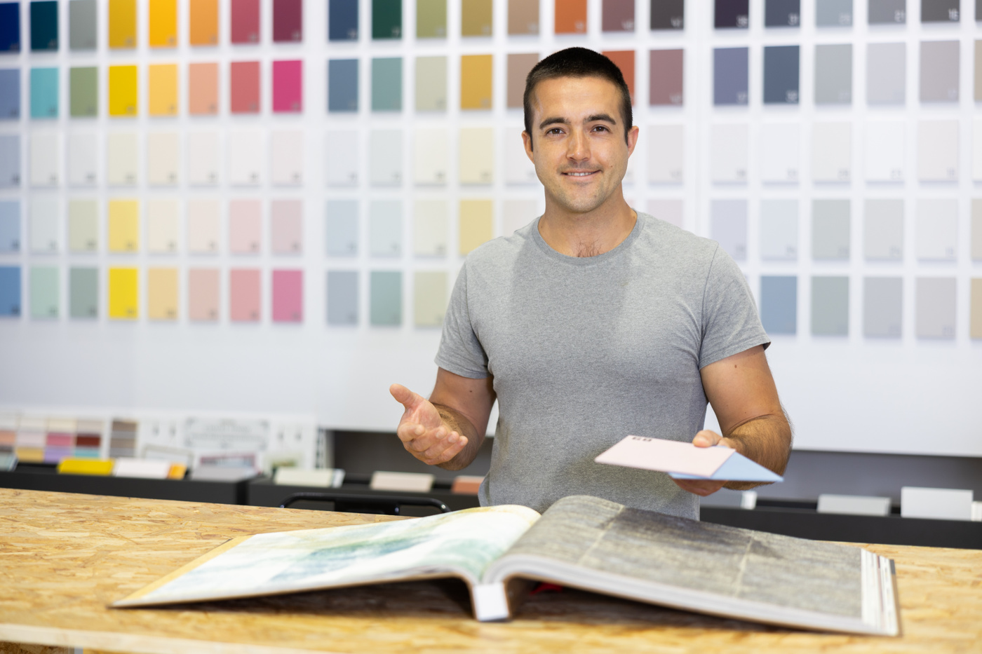 Un planificateur d'aménagement avec brevet fédéral détermine la couleur appropriée pour de nouveaux rideaux en fonction des besoins de la cliente.