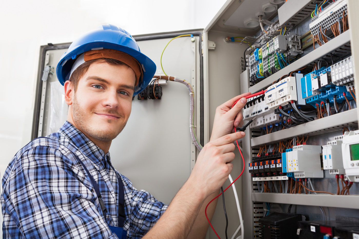 Un installateur électrique titulaire d'un diplôme fédéral évalue une installation électrique et son potentiel d'optimisation.