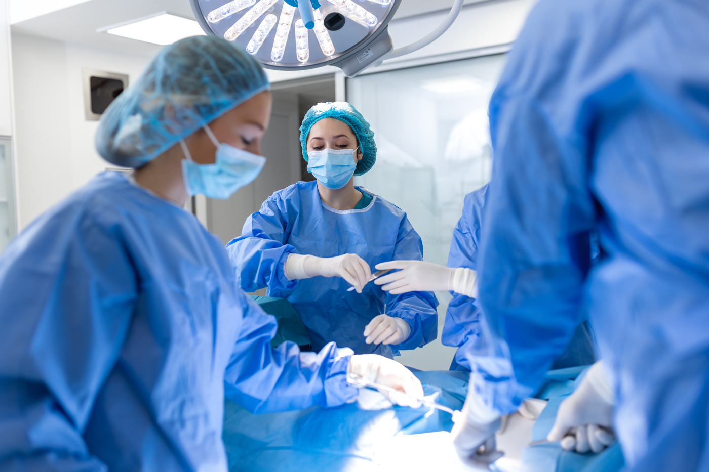 A specialist in surgical technology HF hands the surgeon the scalpel.