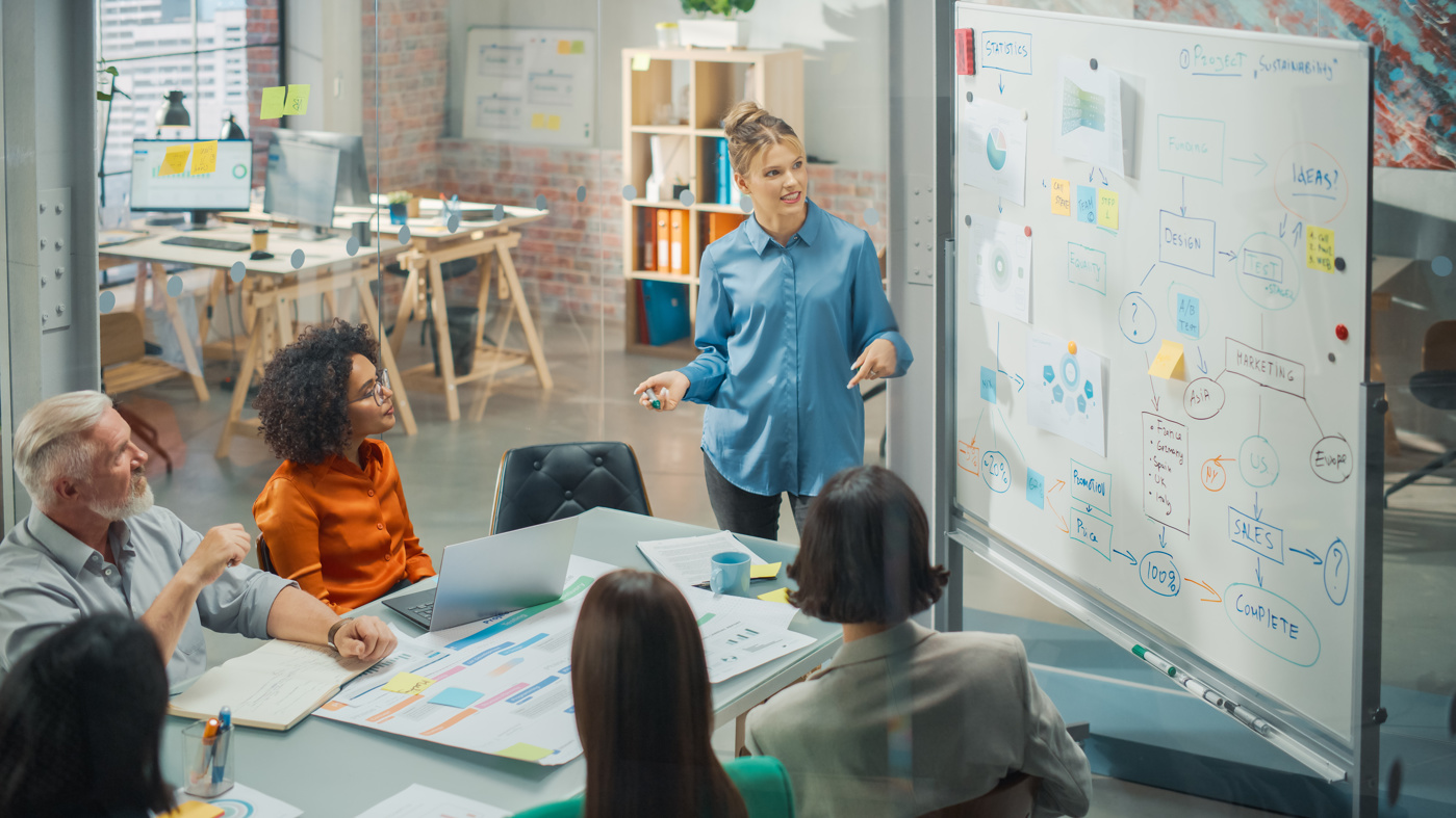 Una responsabile marketing con un diploma HF discute un concetto di marketing con il suo team.
