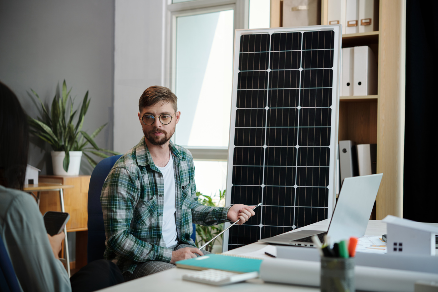 A solar installation project manager with a Federal Diploma of Higher Education shows a potential customer the possibilities for her house.
