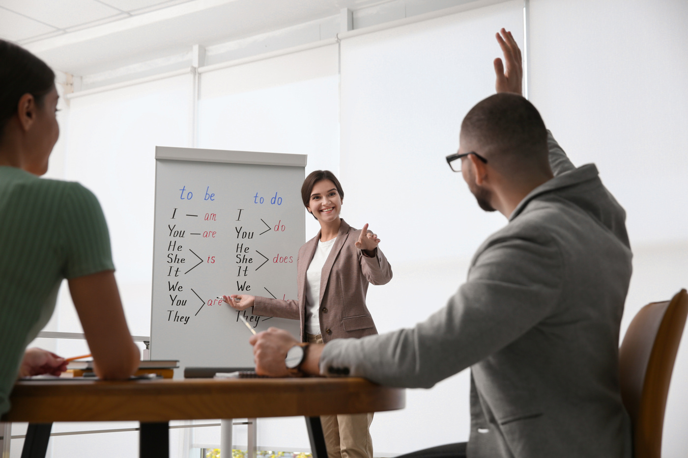 Sprachlehrerin unterrichtet zwei Schüler im Fach HR-Englisch / Personalwesen-Business-Englisch