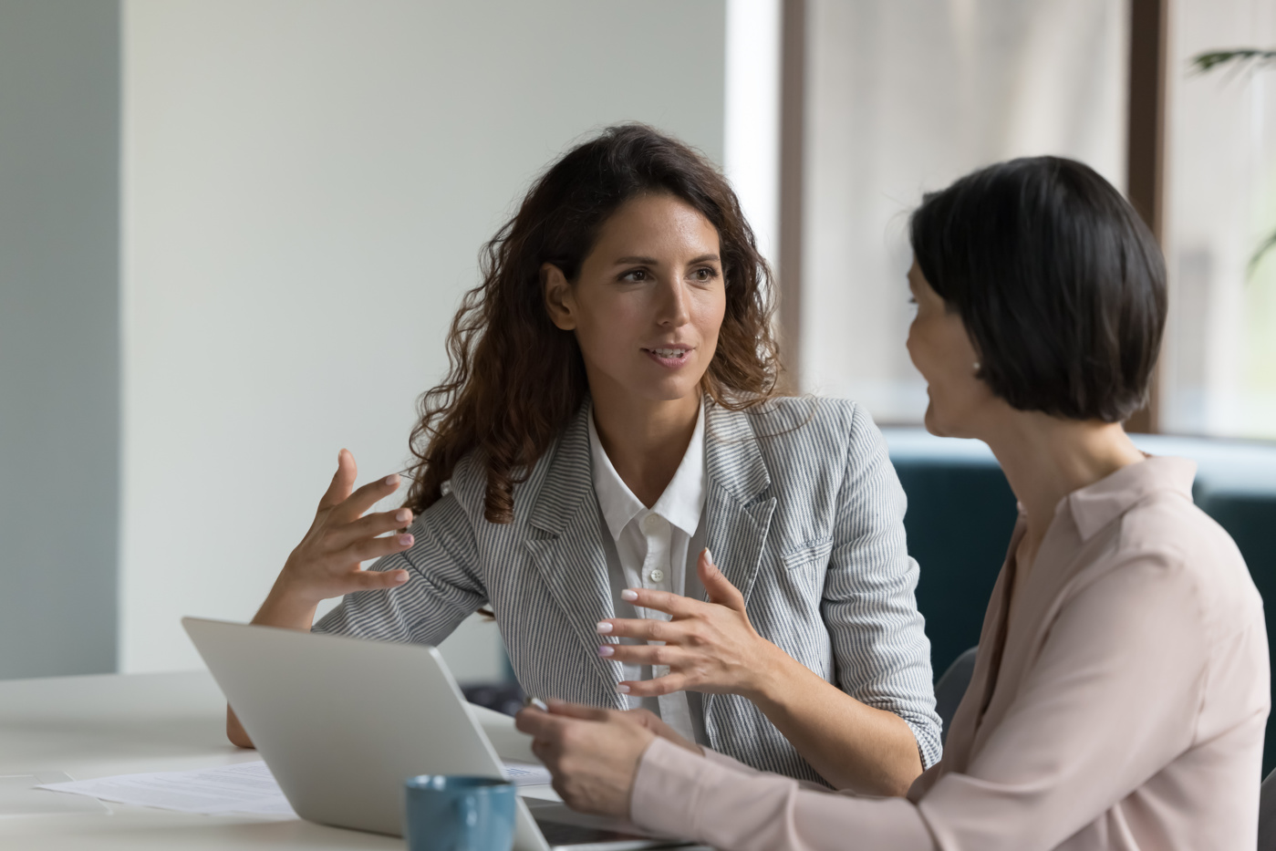 Teilnehmende einer Führungscoaching-Ausbildung sitzen in einem modernen Seminarraum, im Austausch über Leadership-Strategien und Management-Coaching