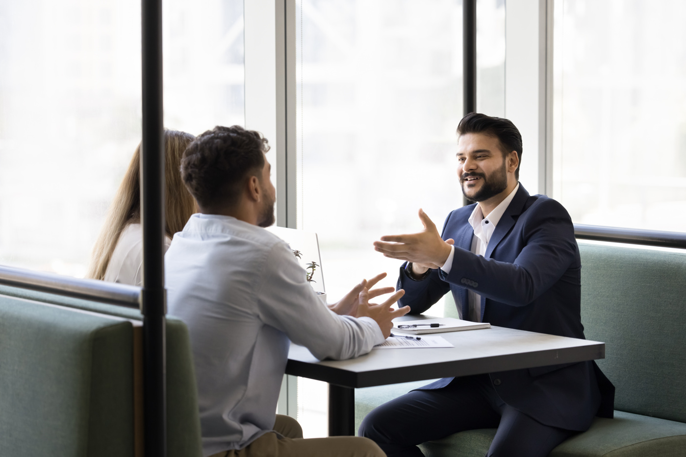 Un esperto di business che dialoga con i colleghi di un team durante una riunione