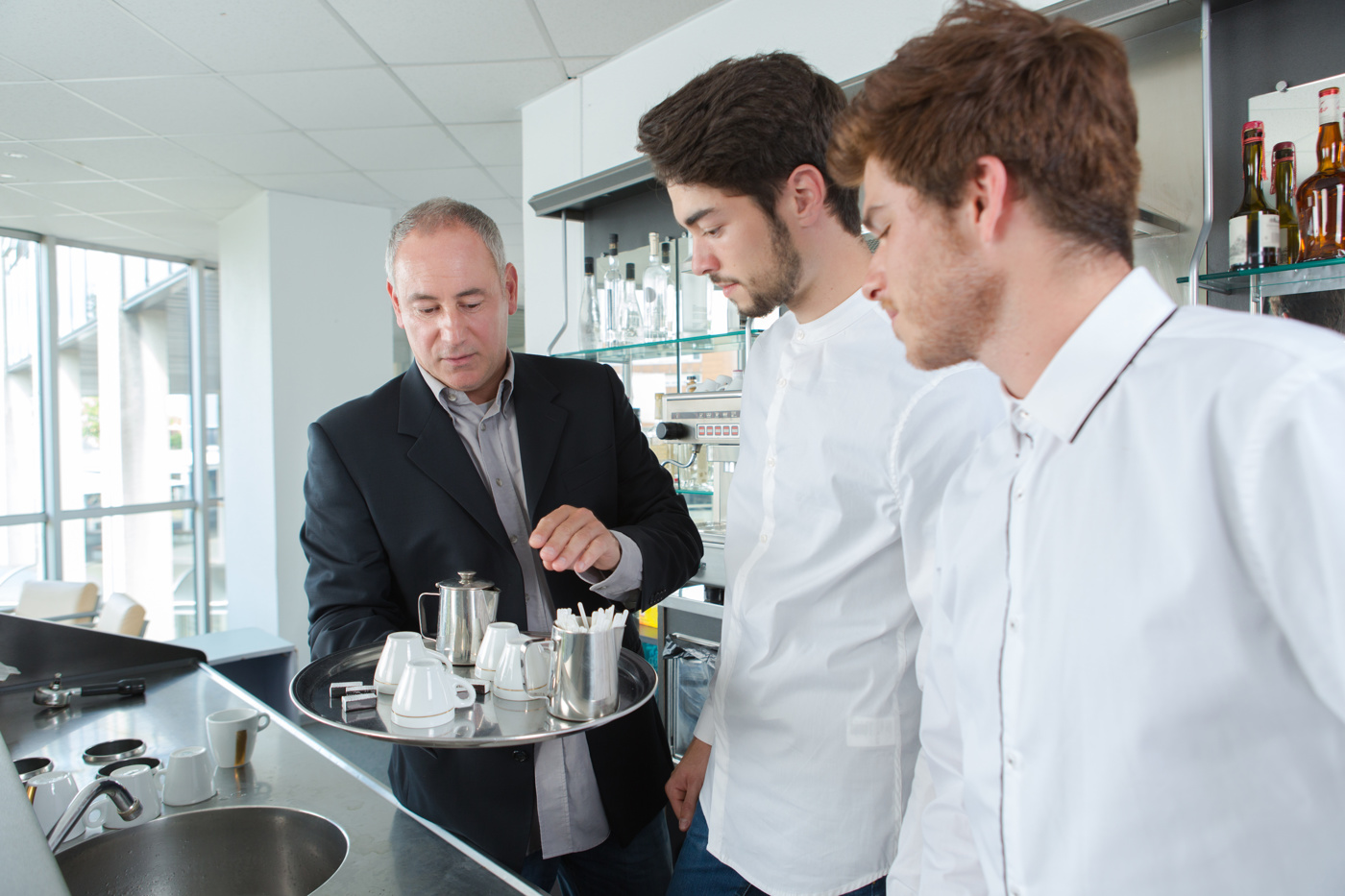 Ein Chef de Service instruiert neue Mitarbeiter, wie sie den Tee oder den Kaffee korrekt servieren.